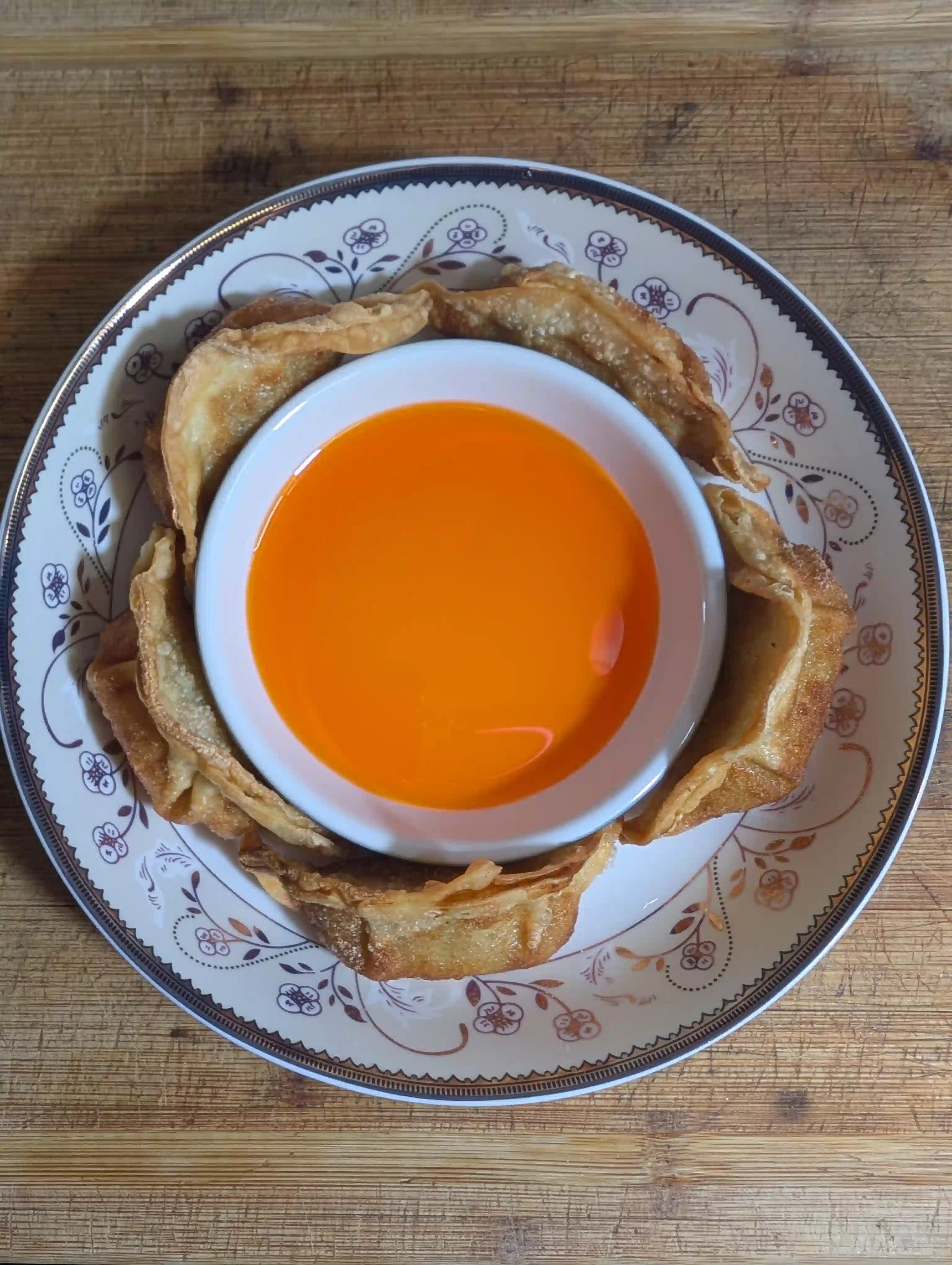 Chili oil in a bowl surrounded by crispy fried gyoza